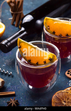 Deux verres de vin chaud avec Clint tranches d'orange parmi les ingrédients pour la cuisine et une bouteille de vin Banque D'Images