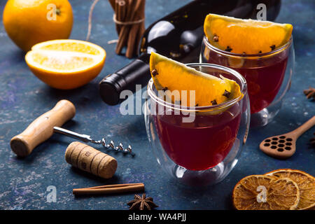 Deux verres de vin chaud avec Clint tranches d'orange parmi les ingrédients pour la cuisine et une bouteille de vin Banque D'Images