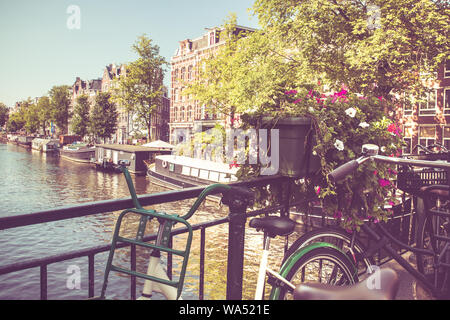 Amsterdam avec des vélos sur le pont sur un canal avec filtre de tonalité vintage. Banque D'Images