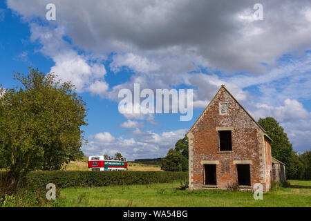 Imber, Wiltshire, Royaume-Uni. 17Th Aug 2019. Transportés à d'autrefois ! Des milliers de visiteurs à profiter de l'occasion de découvrir le village de Imber perdu dans la plaine de Salisbury sur une journée portes ouvertes, Imberbus événement qui exploite plus de 25 anciens et nouveaux Routemaster bus pour emmener les visiteurs à Imber et autres lieux sur la plaine. La population civile de Imber village a été expulsé en 1943 pendant la seconde guerre mondiale et reste un village inhabité, utilisé par l'armée britannique comme terrain d'entraînement. Open top bus passe ancienne ferme Seagram's Farm. Credit : Carolyn Jenkins/Alamy Live News Banque D'Images