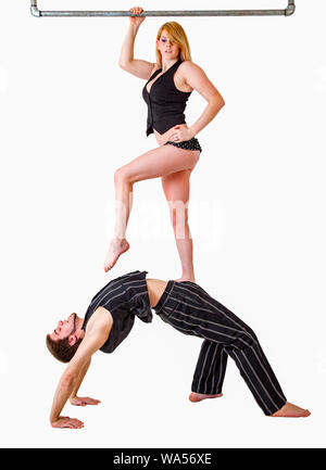 Jeune couple équilibre acrobatique pratiques avec femme debout sur l'homme s'estomac. Banque D'Images