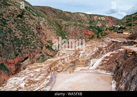 Anciennes mines de sel, Salineras de Maras : des milliers de petits bassins creusés dans le flanc d'une montagne avec des sommets enneigés de montagnes Urubamba sur la zone Banque D'Images