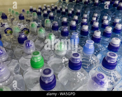 Les bouteilles en plastique avec wate. Rangées de bouteilles en plastique remplies d'eau avec bouchons à vis. Banque D'Images