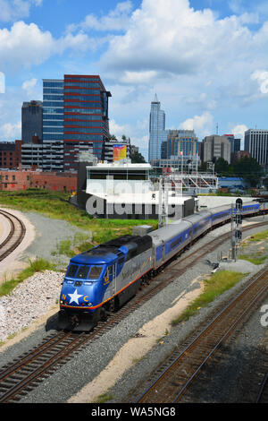 Un train Amtrak quitte la station avec l'horizon de Raleigh dans l'arrière-plan. Vu de l'Boylan Heights quartier. Banque D'Images