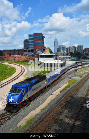 Un train Amtrak quitte la station avec l'horizon de Raleigh dans l'arrière-plan. Vu de l'Boylan Heights quartier. Banque D'Images