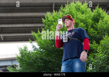 Un homme dans un '2020' shirt Trump fait des vidéos pendant la "fin" du terrorisme national rassemblement à Tom McCall Waterfront Park, le 17 août 2019 à Portland, Oregon. Organisé comme une protestation contre l'anti-fascistes par l'animateur de radio de droite Joe Biggs et membres de la fière des garçons, le rassemblement a attiré un large contingent de counterprotesters y compris Rose City Antifa. Banque D'Images