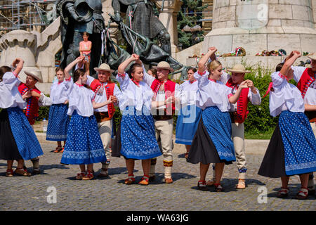 Danse traditionnelle polonaise troup en douane folklorique avec une performance publique square. Danseurs en ligne, avec des mâles virevoltant mesdames sous les armes. Banque D'Images