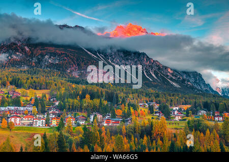 Station de montagne à couper le souffle avec coucher de soleil spectaculaire et haut misty montagnes en arrière-plan, Cortina d'Ampezzo, Dolomites, Tyrol du Sud, Italie, Europe Banque D'Images