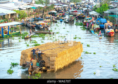 Achat agriculteurs entassés dans le marché flottant matin avec des dizaines de bateaux le long de la rivière du commerce des produits agricoles sert une nouvelle année à Soc Trang Banque D'Images