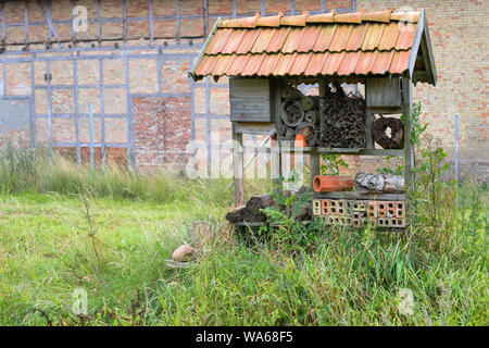 L'abri des insectes et de l'aide d'imbrication avec divers matériaux dans un cadre en bois sous un toit, de l'aide pour les abeilles sauvages, le pollen vole et beaucoup d'autres insec Banque D'Images