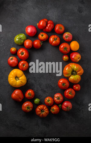 Mot de tomate faite avec les tomates mûres sur un fond noir, creative télévision jeter des aliments sains concept. Banque D'Images