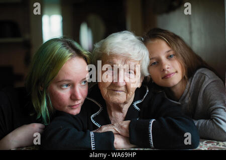 Une vieille femme mamie est photographié pour portrait avec ses arrière-petites-filles. Banque D'Images