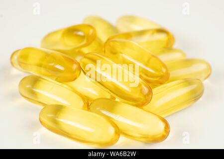 Pile de couleur d'or des capsules d'huile de poisson isolé sur fond blanc. Les capsules du saumon de l'afficher. Omega 3. Vitamine E. la nourriture bonne pour l'hea Banque D'Images