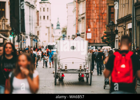 Cracovie, Pologne. Transport en autocar à l'ancienne se déplaçant à Vieille Ville Rue en journée d'été. Visite des Sites Historiques Banque D'Images