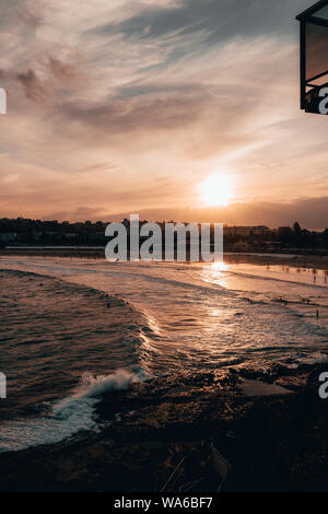 Coucher du soleil sur la plage de Bondi chaud par une froide après-midi d'hiver. Banque D'Images