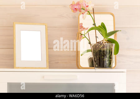 Structure en bois, des maquettes et une orchidée phalaenopsis blanc sur la poitrine dans une chambre d'une maison en bois avec garnitures blanches. Banque D'Images