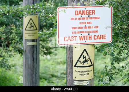 Danger pour la pêche électrique en fonte avec soin des câbles aériens sign Banque D'Images