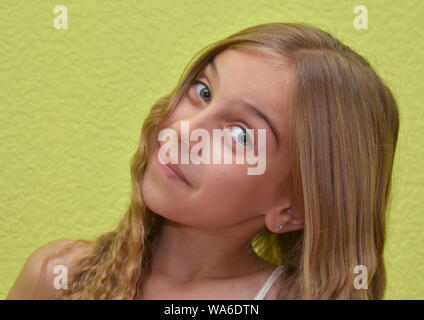 Jeune fille blonde en souriant avec caméra fond vert clair Banque D'Images