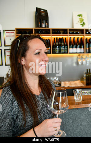 Woman holding glass dégustation de vin et de passer un bon moment en velo Vins cave Porte, Legana Tasmanie, Australie Banque D'Images