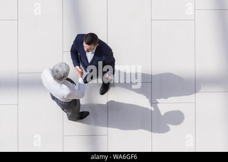 Partenaires d'affaires se serrer la main comme symbole d'unité, vue d'en haut Banque D'Images