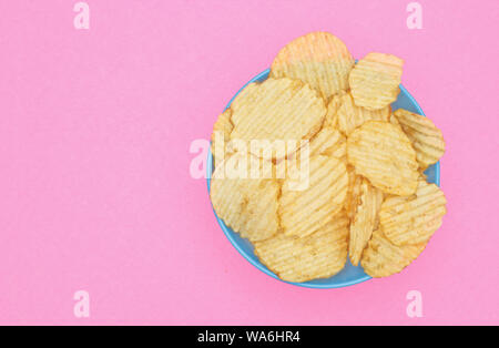 Croustilles de pommes de terre dans le bol bleu rose. Banque D'Images