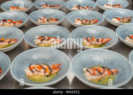 De nombreuses planches aux crevettes sur une table de cuisine dans un restaurant. Banque D'Images