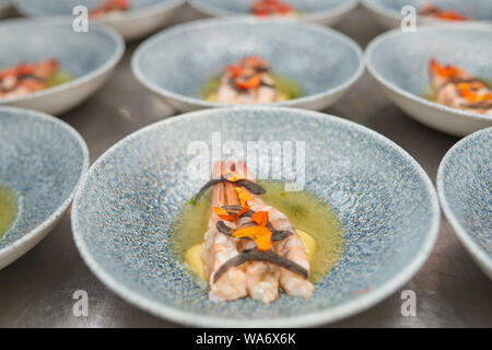 De nombreuses planches aux crevettes sur une table de cuisine dans un restaurant. Banque D'Images