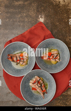 De nombreuses planches aux crevettes sur une table de cuisine dans un restaurant. Banque D'Images