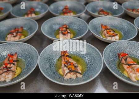 De nombreuses planches aux crevettes sur une table de cuisine dans un restaurant. Banque D'Images