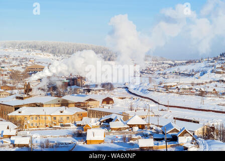 Vue générale de l'Oural avec une petite usine métallurgique dans la vallée de la rivière sur un beau jour d'hiver glacial Banque D'Images