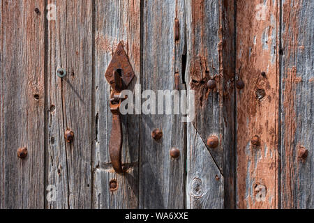 Loquet rouillé sur porte en bois patiné - France. Banque D'Images
