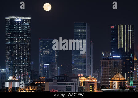 Aug,16,2019-Chengdu, Chine-skyscapers éclairés la nuit avec la pleine lune en arrière-plan, Chengdu, Chine Banque D'Images