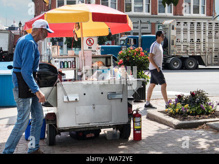 Au premier plan vous voyez un stand hotdog. Cyniquement, dans la rue, derrière, les cochons vont à l'abattoir dans un camion agricole, Stratford, Ontario. Banque D'Images