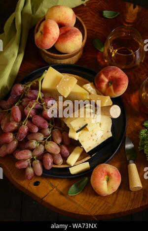 Du fromage, du raisin et du vin sur une table en bois de style rustique, Banque D'Images