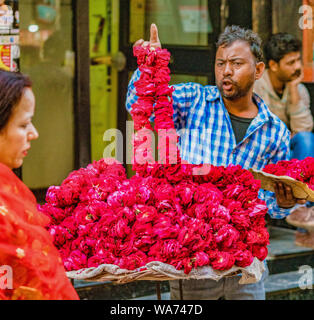Vrindavan, Inde - 22 février 2018 - l'homme vend des fleurs fraîches rouge de sa table de rues Banque D'Images
