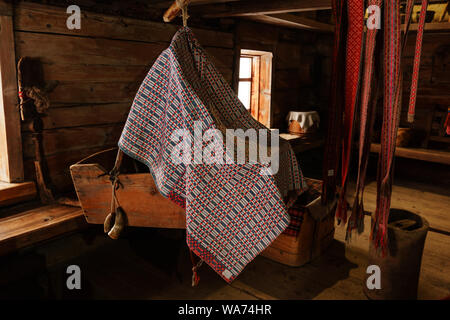 Fragment de l'intérieur d'un vieux paysan log cabin avec une station d'accueil, et les ceintures à motifs tissés quenouille Banque D'Images