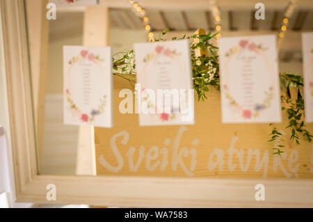 Table de mariage assis sur des cartes graphique joint à un miroir et la réflexion de feuilles vertes Banque D'Images
