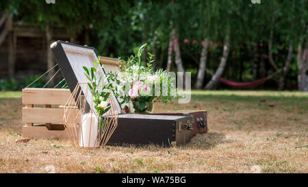 Un couple de vieux vintage valises sur le sol décoré de quelques fleurs annonce une bougie Banque D'Images