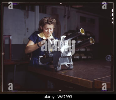 Une jeune femme employée de North American Aviation, Incorporated, travaillant sur le mécanisme d'atterrissage d'un avion de chasse P-51, Inglewood, Californie Le mécanisme ressemble à un petit Cannon Banque D'Images