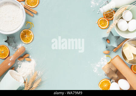 Fond bleu avec les matières premières pour la pâtisserie, biscuits des fêtes ou des gâteaux secs avec des oranges, des noix et d'épices, lumineux vue supérieure de la composition Banque D'Images