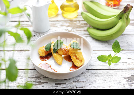 Les bananes frit avec sauce au caramel et noix de coco en flocons. Dessert sucré. Banque D'Images