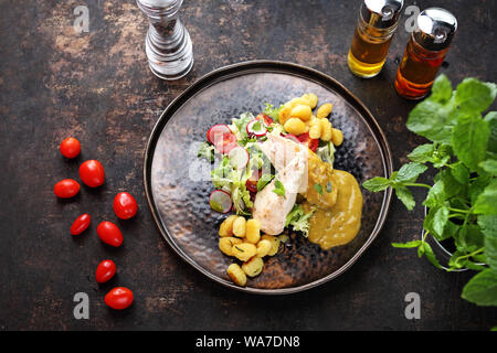 Filet de poulet en sauce au gorgonzola servi avec gnocchi et salade verte Banque D'Images