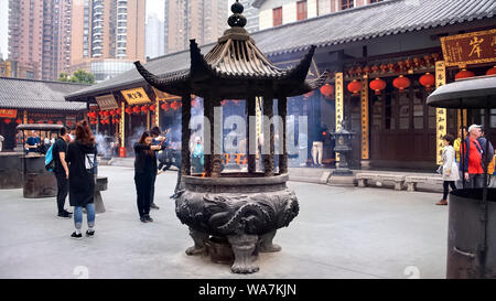 Brûleur d'encens au Temple du Bouddha de Jade à Shanghai, Chine. Montrant une jeune femme en prière avec l'encens. Banque D'Images