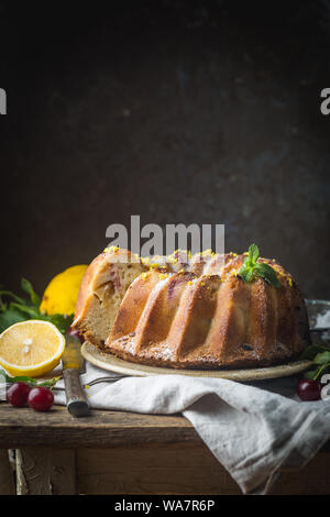 Gâteau bundt citron fait maison de sucre glace sur un fond noir Banque D'Images