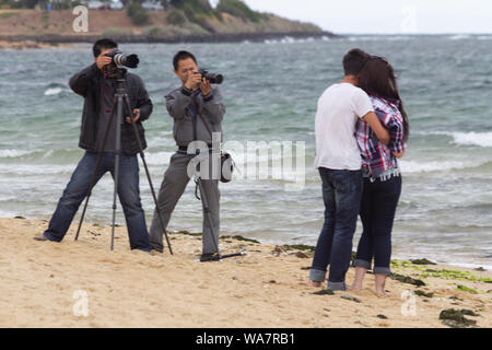 Melbourne, Australie. Les photographes professionnels sur la plage de Brighton en photographiant jeune couple, femme et homme. Banque D'Images