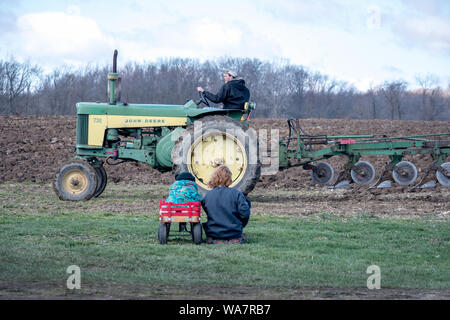 28 avril 2018 Buchanan MI USA ; maman et enfant regardent l'agriculteur labourer son champ Banque D'Images