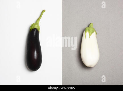 Sombre et aubergines blanches isolé sur fond duotone. Concept de différence. Banque D'Images