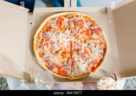 Pizza italienne dans la boîte en carton sur la table. Vue d'en haut Banque D'Images