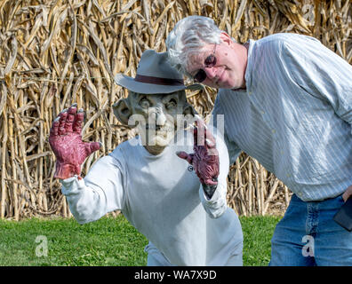 L'homme pose avec un mannequin extérieur effrayant lors d'un événement d'Halloween Banque D'Images