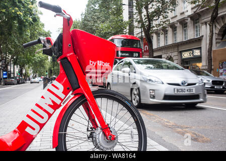 Londres, UK - Août 2019 : Dockless rouge saut vélo électrique exploité par Uber dans une rue dans le centre de Londres. Banque D'Images